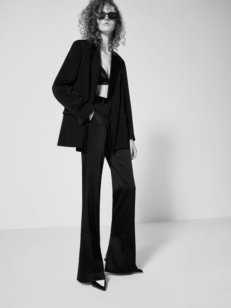 MO&Co. Bowknot Details Structured Blazer in Black. Made from comfy, smooth acetate blend materials with intricate bowknot and slit details on the back, this blazer also includes shoulder pads and a button closure.