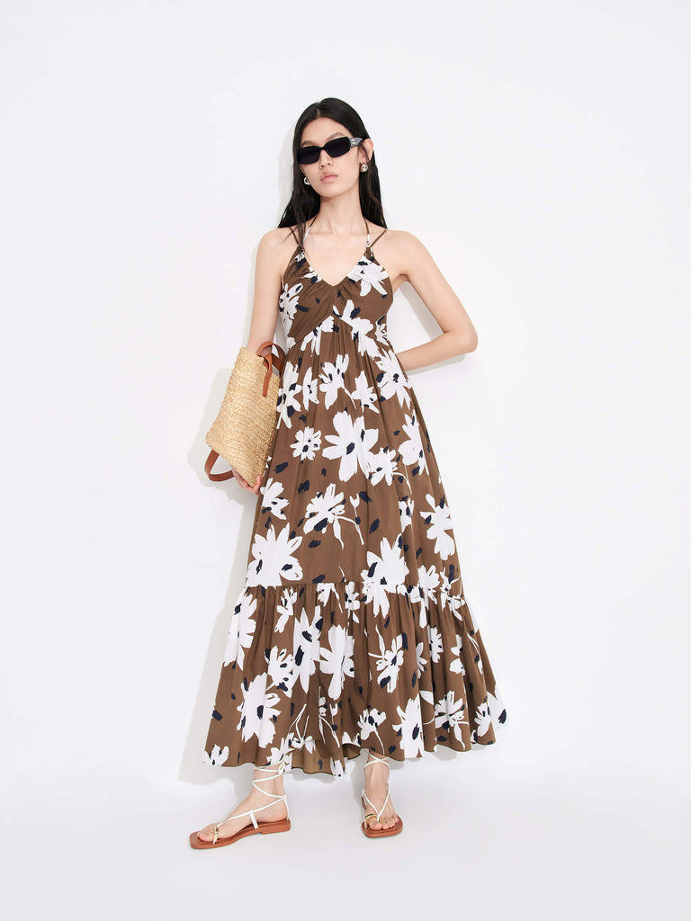 MO&Co. Women's Tropical Floral Print Vacation Maxi Dress in Brown features a V-neck, pleated details, cascading skirt and halterneck tie.