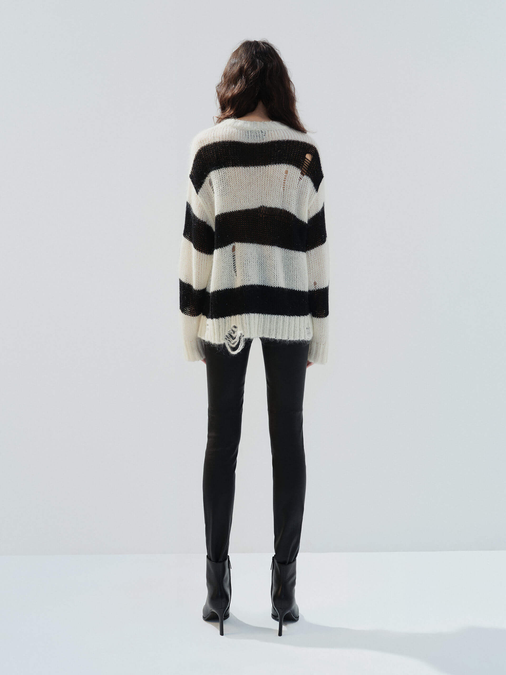 MO&Co. Noir Women's Distressed Detail Striped Oversized Pullover Crafted from a blend of mohair and wool, this sweater offers a fuzzy texture and distressed design for a modern twist.