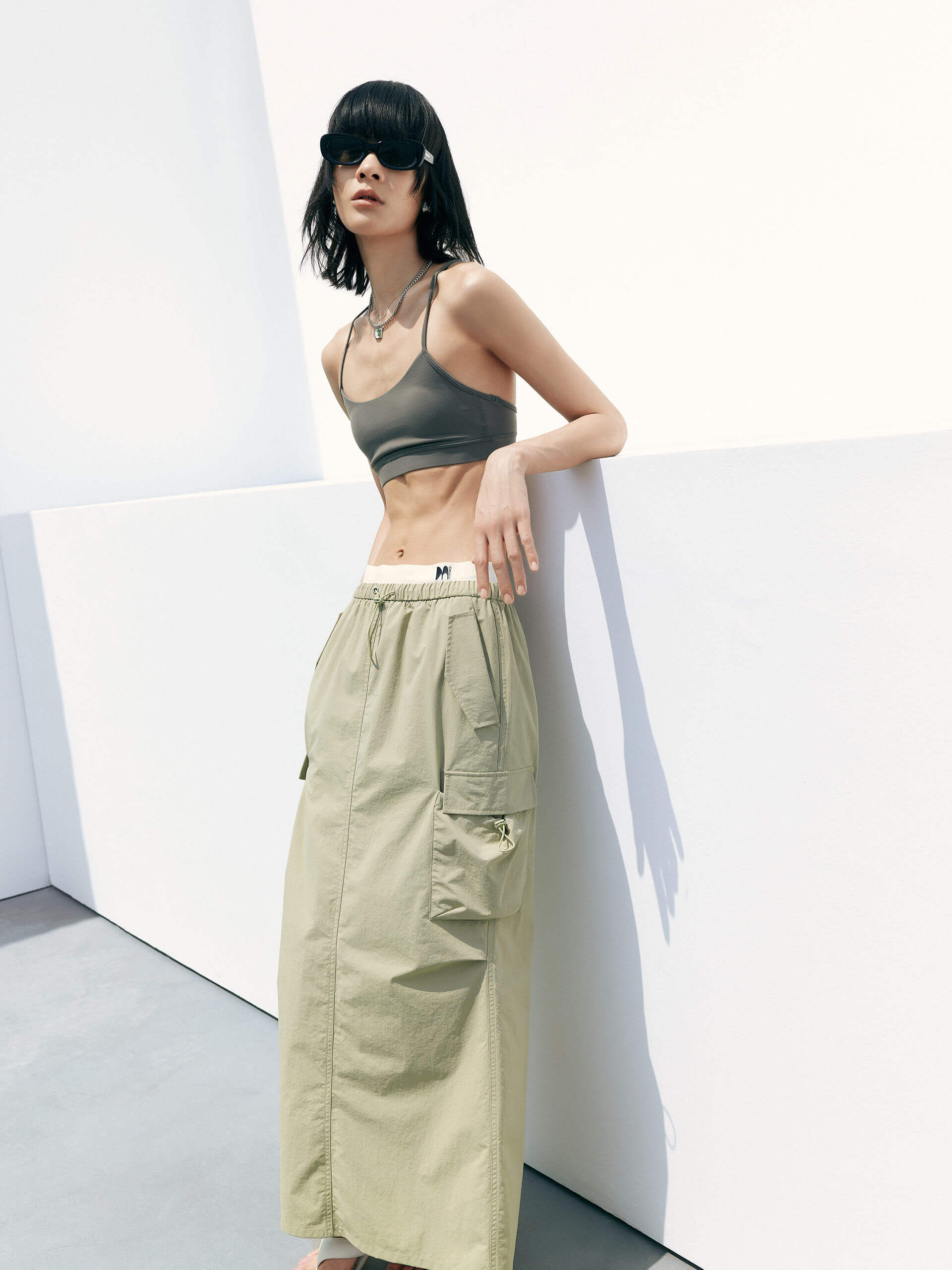 MO&Co. Women's Cropped Sports Bra in Olive offers versatile style ideal for any activity. Its scoop neck, racerback, and elasticized hem provide ultimate comfort. Plus, it features UPF 40+ sun protection. Crafted with cool touch fabric and equipped with non-adjustable thin straps and removable cups.