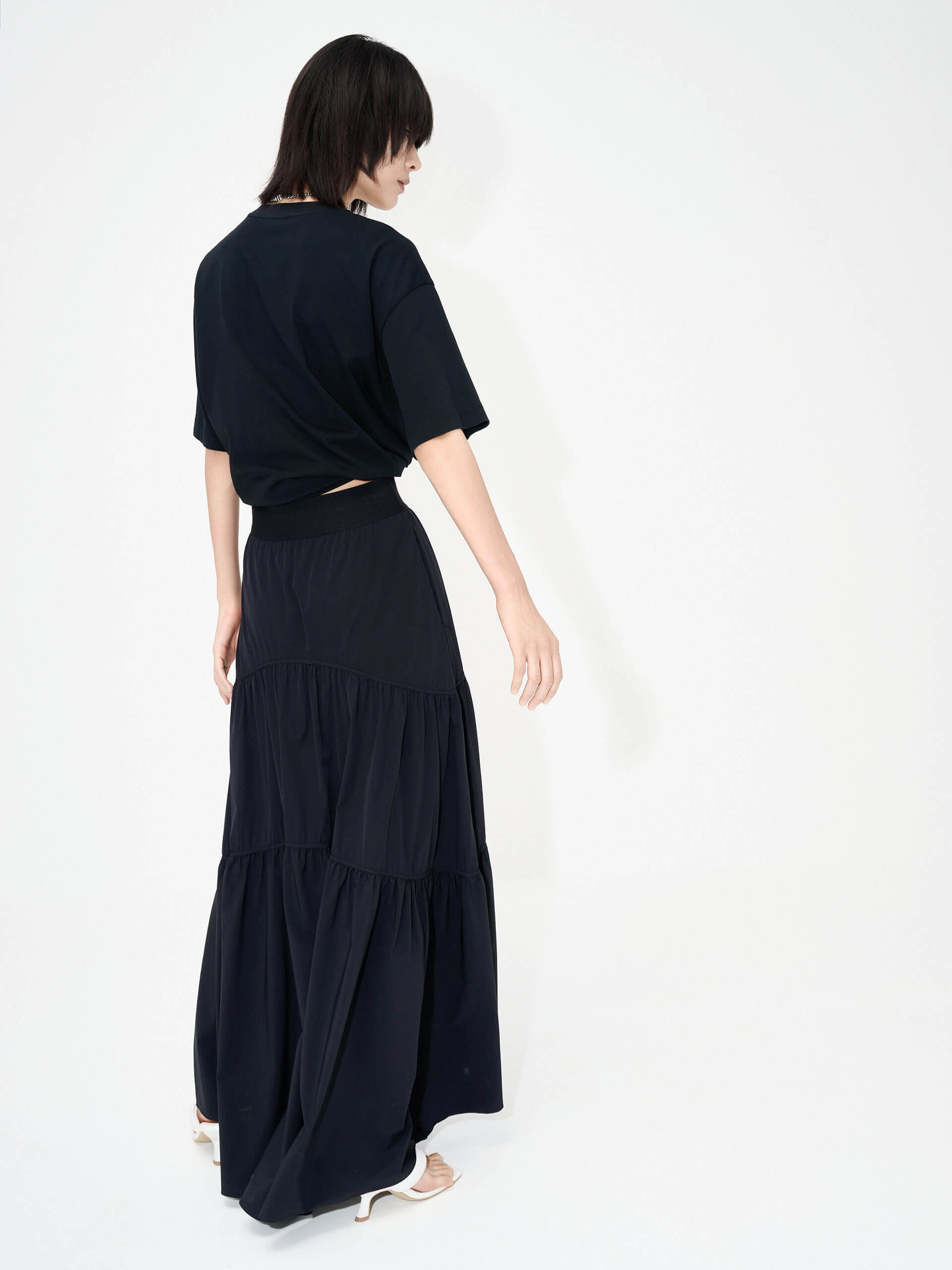 MO&Co. Women's Flowy Prairie Maxi Skirt in Black for Summer Day features double side pockets, cool-touch fabric, an elasticized waistband, and gathered seam details for a perfect fit.