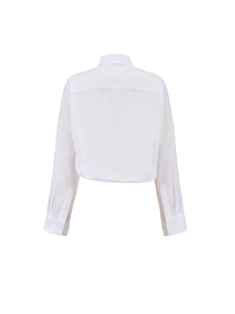 MO&Co. Women's Slanted Placket Cropped Shirt in White. Crafted with a stylish cropped silhouette and slanted placket design, this fashion-forward piece is bound to turn heads. Plus, it's complete with a front pocket and elastic hem for a unique look.