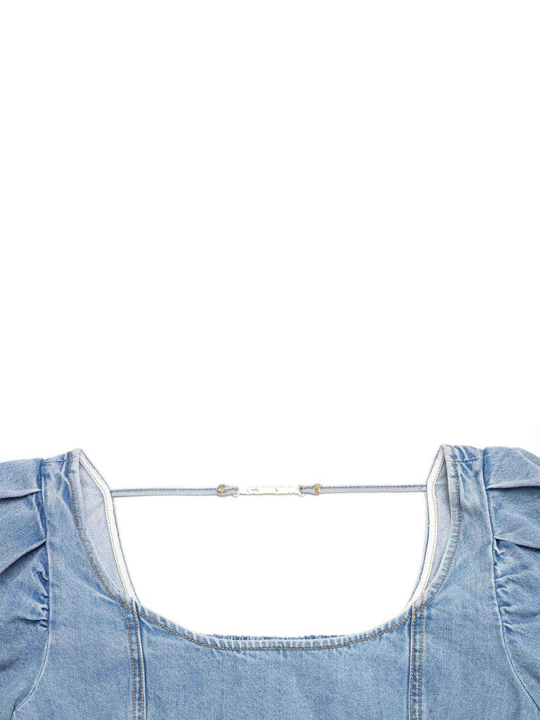 MO&Co. Women's Puff Sleeves Denim Cropped Top in Blue features puff sleeves and a smocked back with metallic tie details.