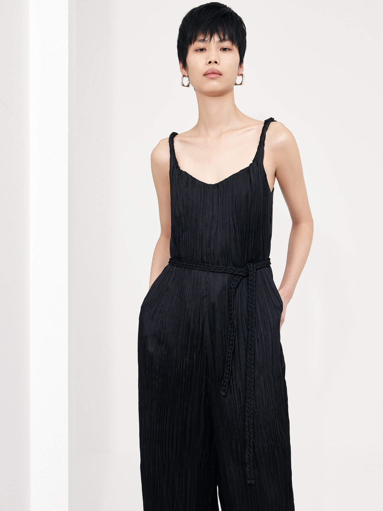 MO&Co. Women's Textured Wide Leg Jumpsuit in Black features an included belt & double side pocket design. Its elegantly draped & twisted shoulder strap completes the look for a timeless classic.