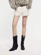 MO&Co. Noir Women's Fringed Denim Shorts in White. Crafted from high-quality Turkish cotton, these shorts feature a trendy distressed design and sequin-decorated longer pockets for a touch of glamour.