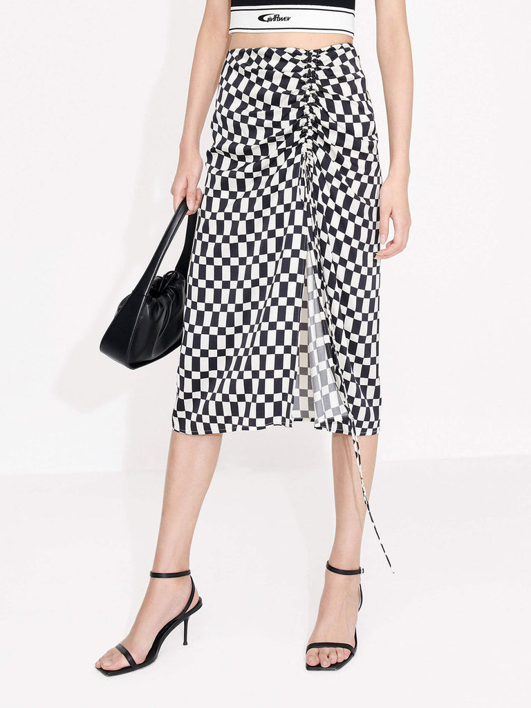 MO&Co. Women's Chessboard Pattern Skirt features modern bold chessboard pattern in black and white. Crafted with pleated drawstring design for an elegant look, finished with a hidden side zipper closure and side slit.