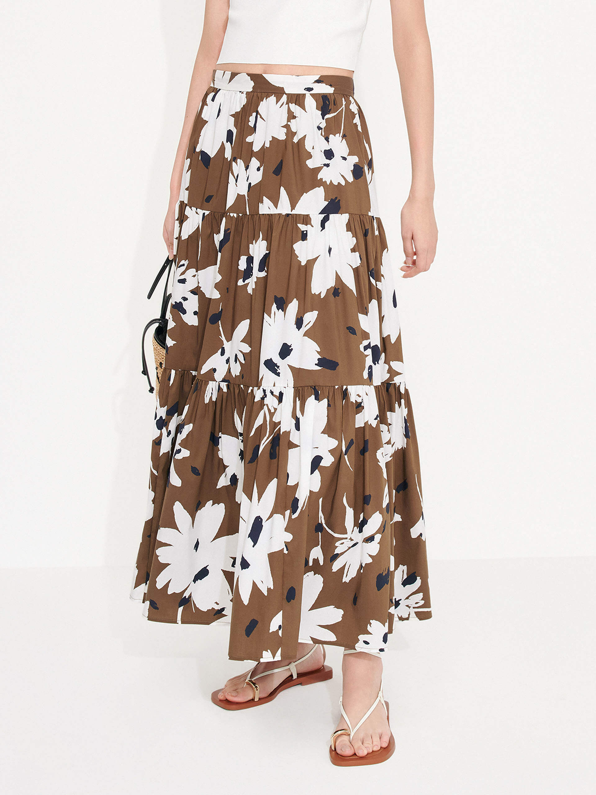 MO&Co. Women's Tiered Floral Print Maxi Skirt in Brown features a flowy fit, high waist and pleated design. Plus, the bold floral print and side zipper closure create a standout style.