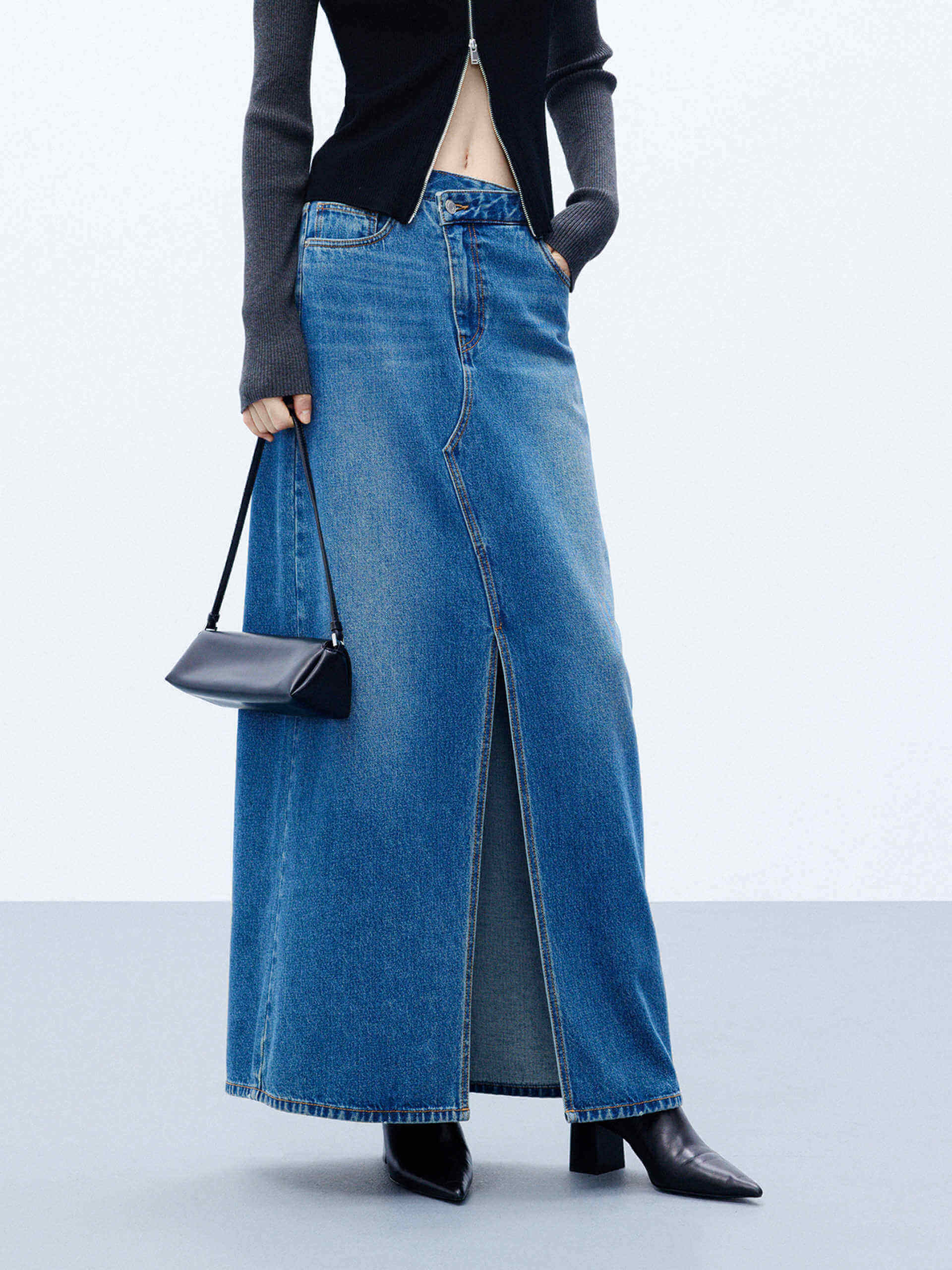 MO&Co. Women's Blue Front Split Maxi Denim Skirt boasting an asymmetrical waistband & an eye-catching front slit. With five classic pockets & button & zip closure, this maxi length skirt is a must-have for any event.