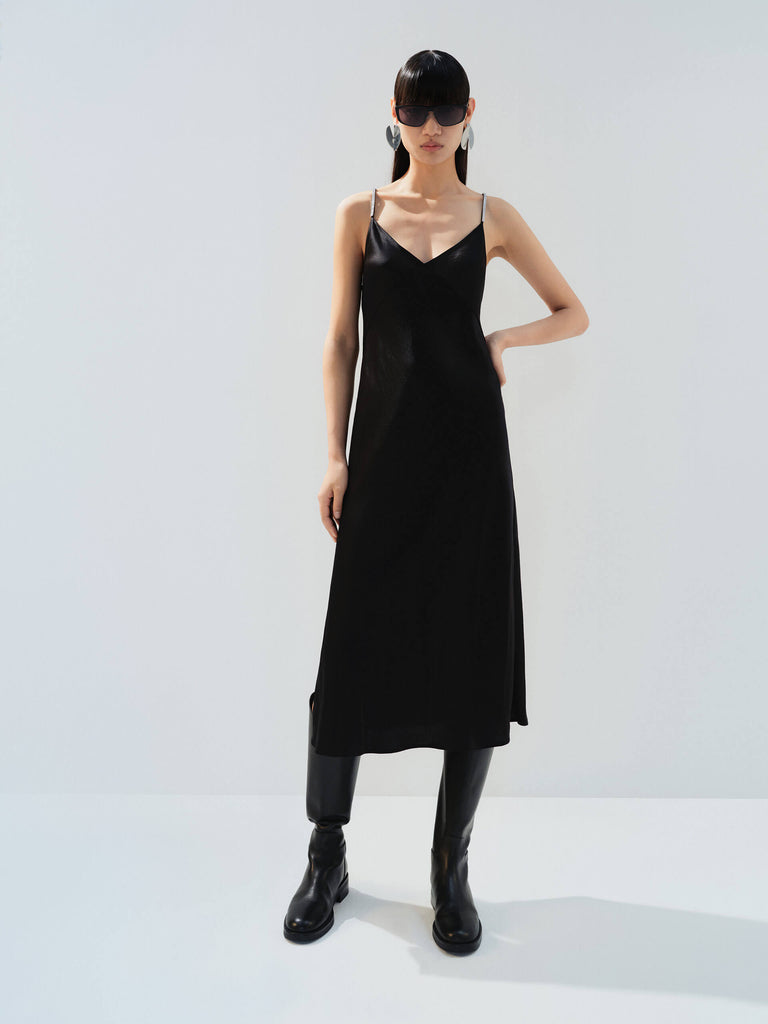 MO&Co. Noir Women's Rhinestones Detail Black Silky Dress offers a smooth touch and elegant drape. Featuring crossover rhinestone shoulder straps, a V-neckline, and a side slit with a curvy waistline.