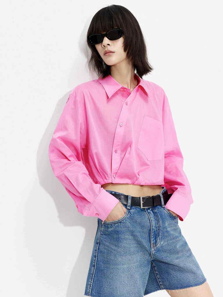 MO&Co. Women's Slanted Placket Cropped Shirt in Pink. Crafted with a stylish cropped silhouette and slanted placket design, this fashion-forward piece is bound to turn heads. Plus, it's complete with a front pocket and elastic hem for a unique look.