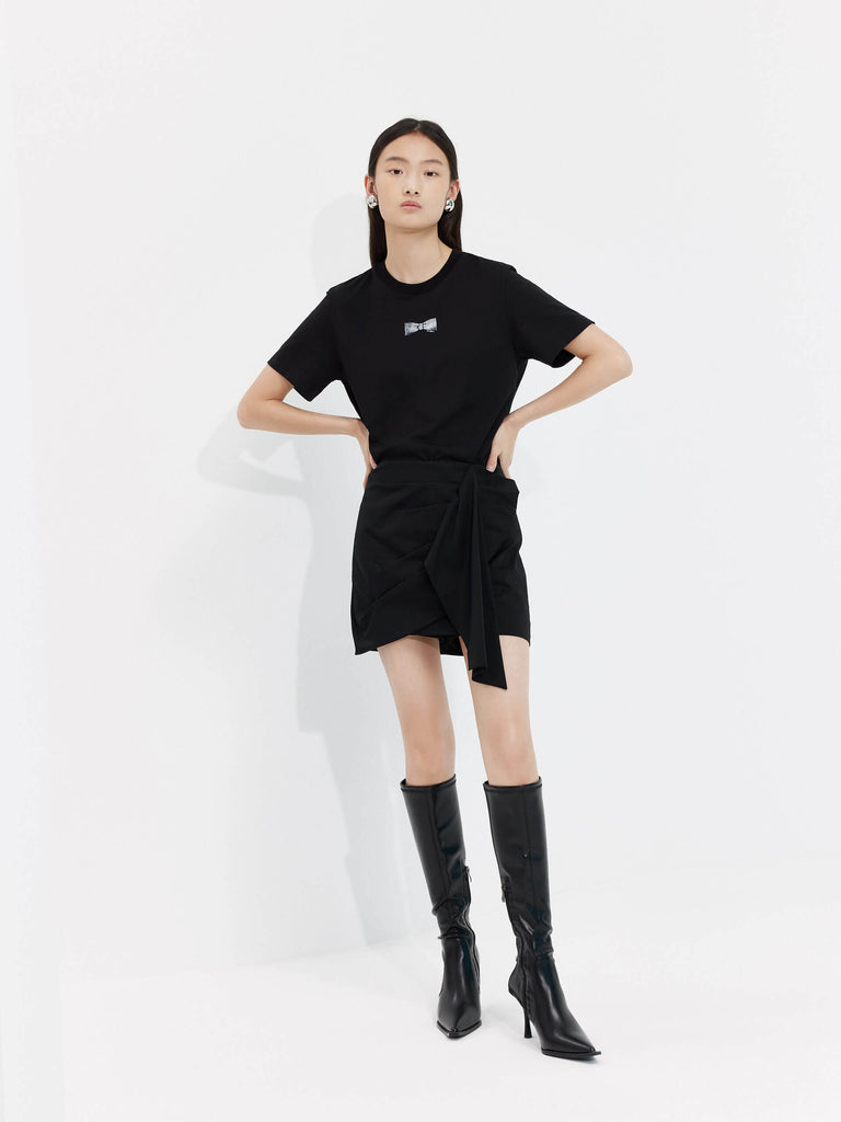 MO&Co. Women's Deconstructed Pleated Skirt in black. It features flattering pleats and draped front, inner shorts and a-line silhouette.