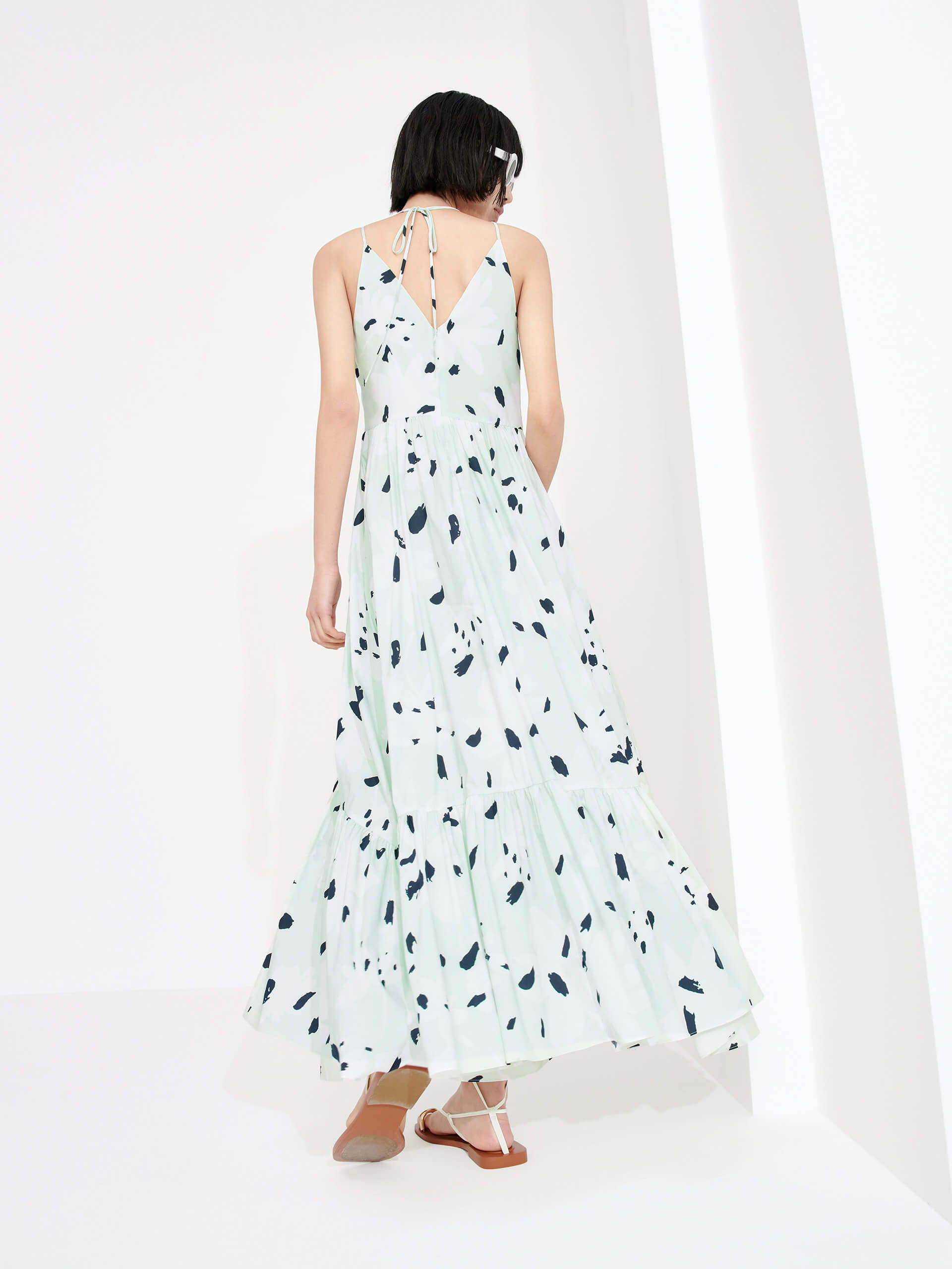 MO&Co. Women's Tropical Floral Print Vacation Maxi Dress in Mint features a V-neck, pleated details, cascading skirt and halterneck tie.