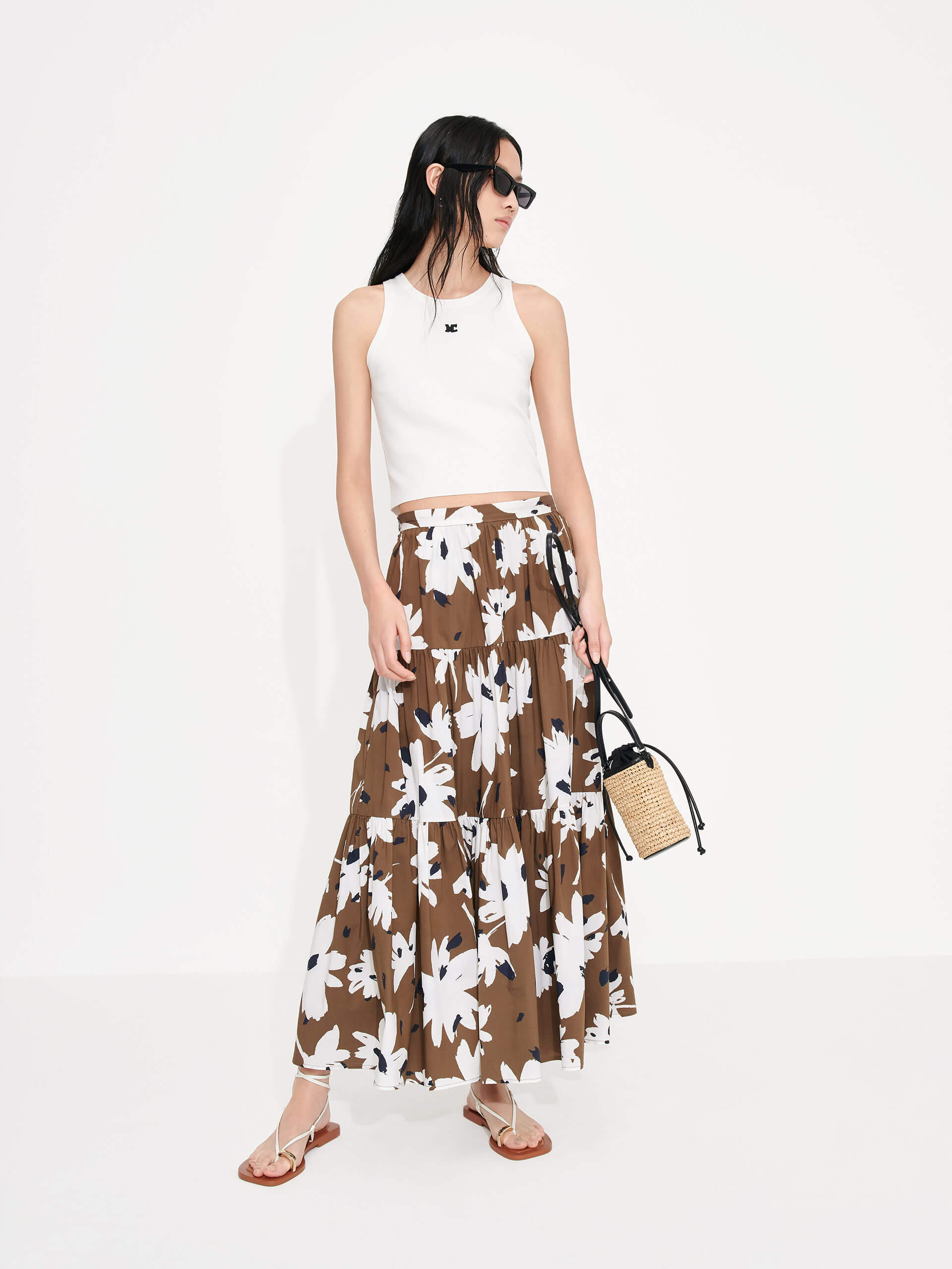 MO&Co. Women's Tiered Floral Print Maxi Skirt in Brown features a flowy fit, high waist and pleated design. Plus, the bold floral print and side zipper closure create a standout style.