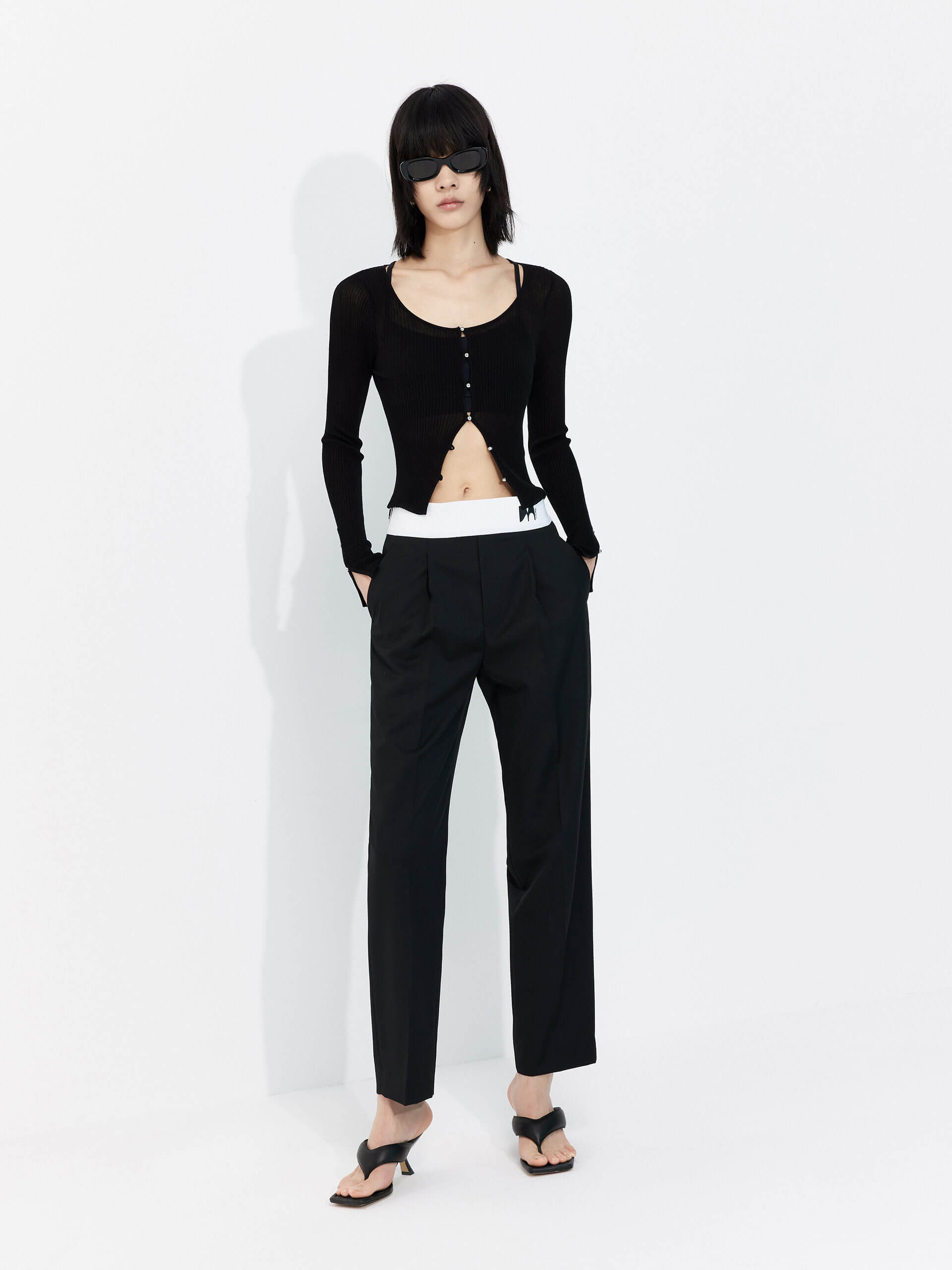 MO&Co. Women's Contrasting Details Suit Pants in Black. Crafted with a luxurious wool blend and featuring an eye-catching elastic waistband with an M pattern, these pants are designed for comfort and style. Double-side pockets and side zip closure complete the look.