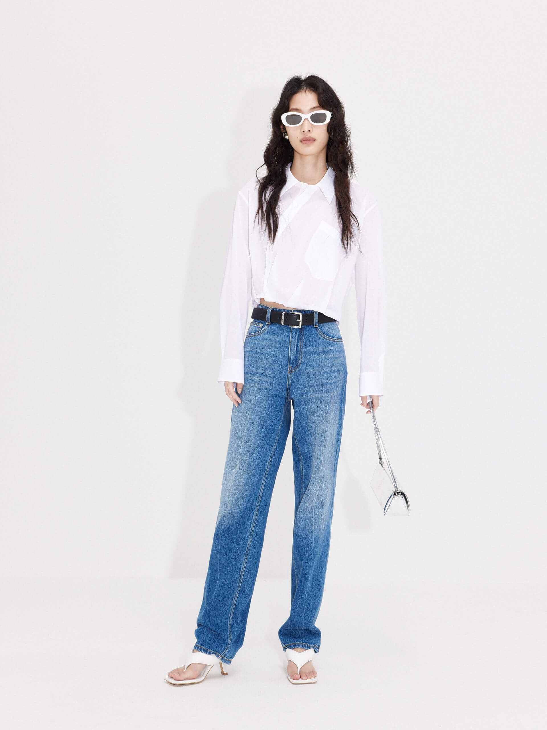 MO&Co. Women's Slanted Placket Cropped Shirt in White. Crafted with a stylish cropped silhouette and slanted placket design, this fashion-forward piece is bound to turn heads. Plus, it's complete with a front pocket and elastic hem for a unique look.