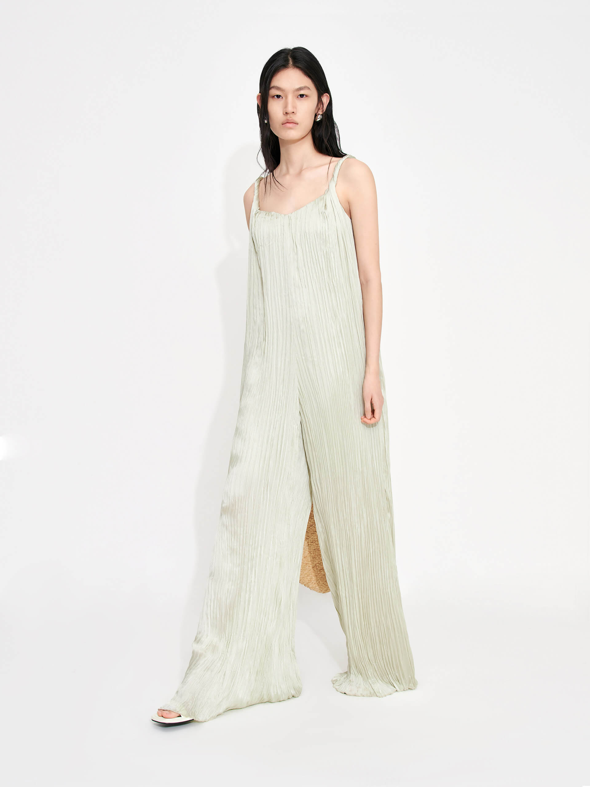 MO&Co. Women's Textured Wide Leg Jumpsuit in Mint features an included belt & double side pocket design. Its elegantly draped & twisted shoulder strap completes the look for a timeless classic.