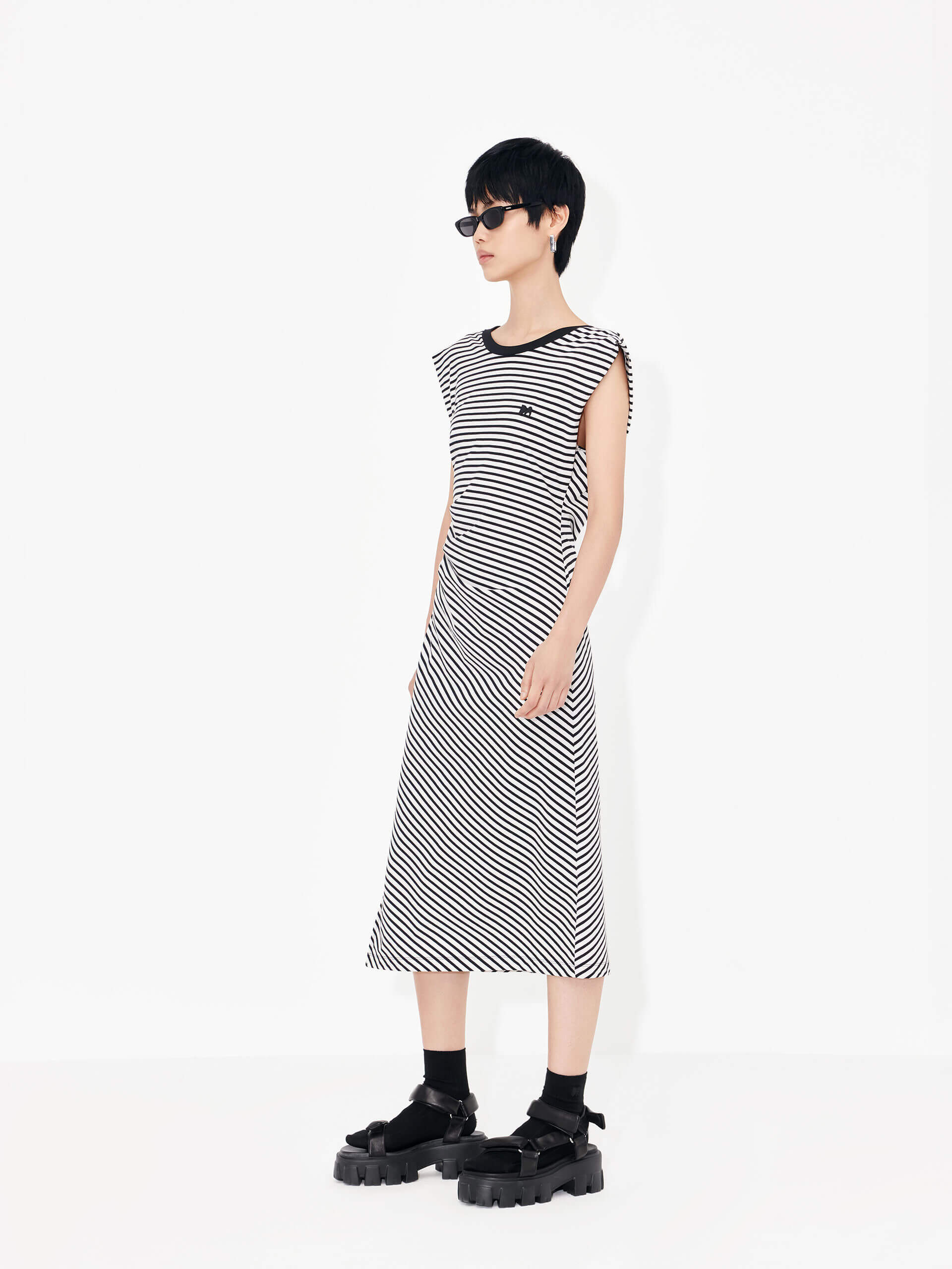 Be effortlessly elegant in this MO&Co. Gathered Waist Stripe dress in Classic Black and White. It features a timeless black and white striped pattern, a pleated gathering at the waist, a cross design at the back, and wide shoulders for a flattering silhouette.