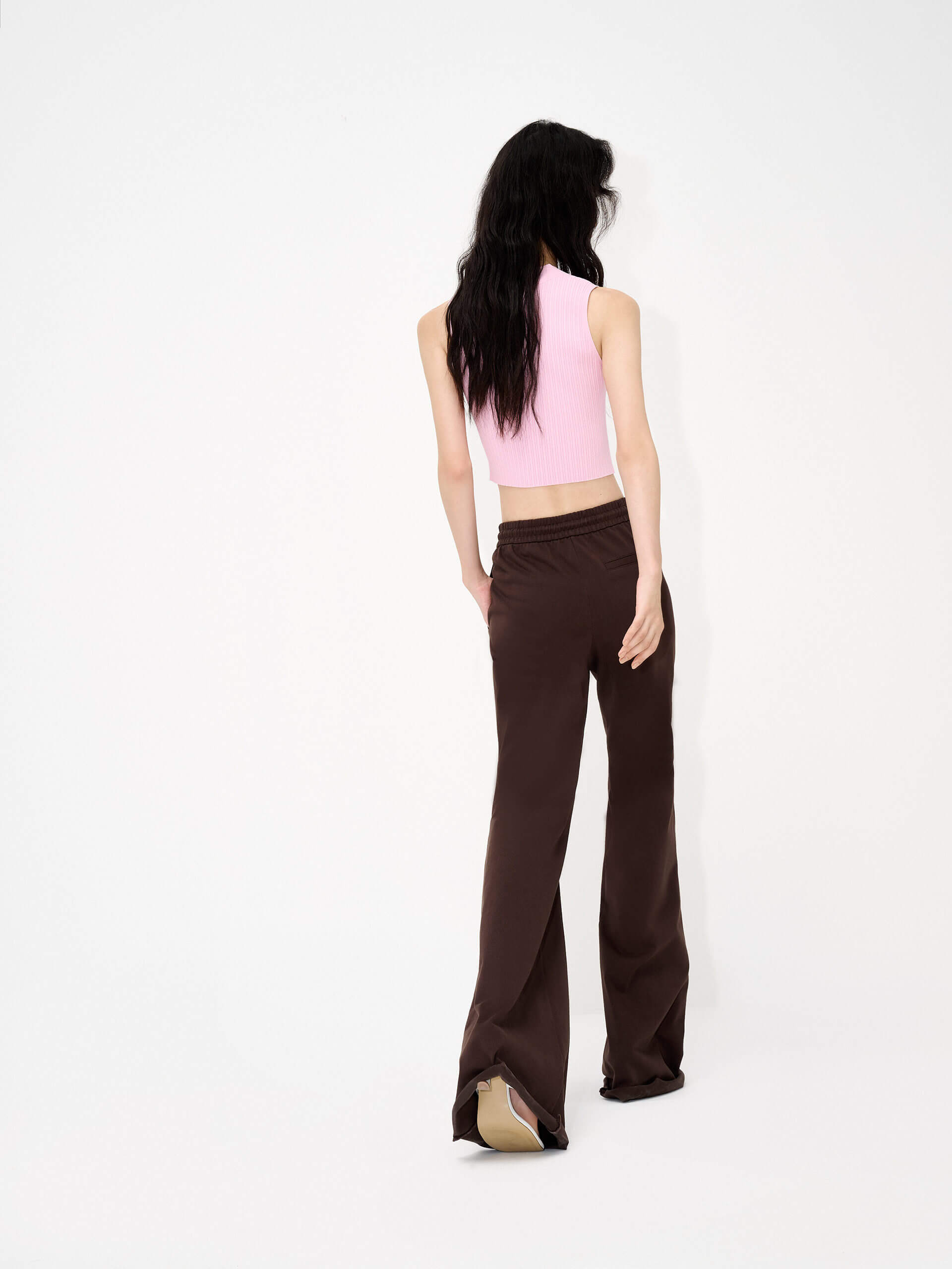 MO&Co.'s Drawstring Waist Causal Flared Sweatpants in Brown. Crafted from soft cotton, these trousers feature a relaxed fit with drawstrings and elastic waistband for comfort. They also come with flared legs and double side pockets with MC embroidery details.