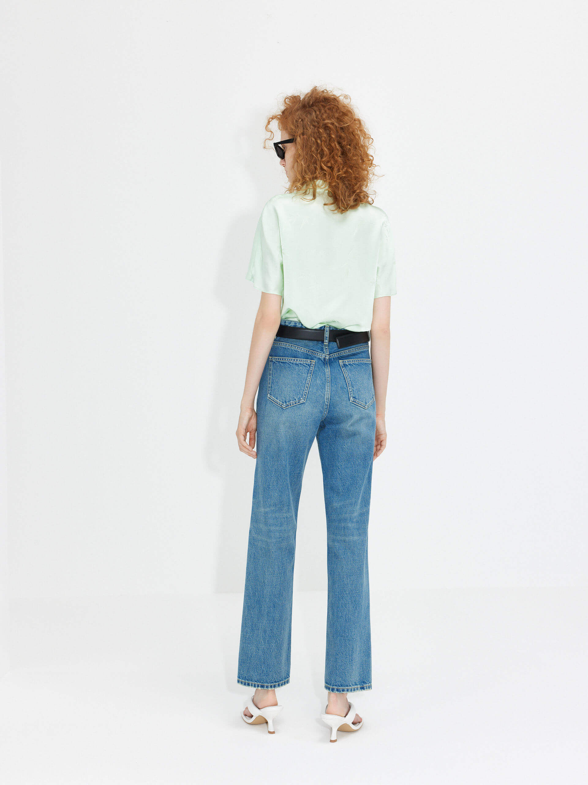 MO&Co. Women's Mid Waist Straight Whiskered Jeans in Blue features a secure button and zip closure, roomy five-pocket design, and easy accessorizing via the belt loops.