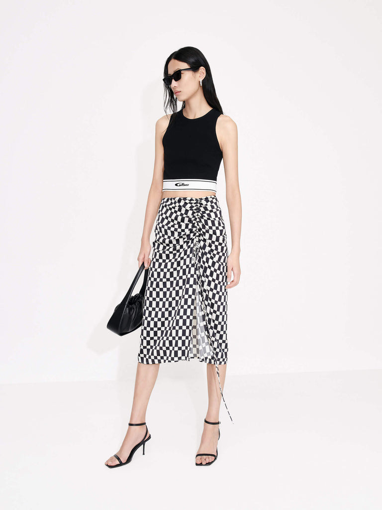 MO&Co. Women's Chessboard Pattern Skirt features modern bold chessboard pattern in black and white. Crafted with pleated drawstring design for an elegant look, finished with a hidden side zipper closure and side slit.