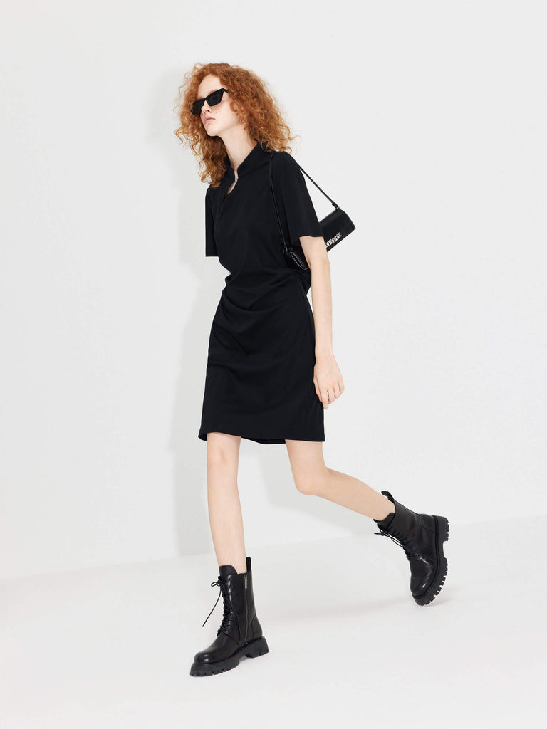 MO&Co. Women's Stand Collar Pleated Mini Dress in Black showcases an accentuated waistline, classic mandarin collar, and a unique slanted placket with metal button details for a perfect blend of classic and modern.