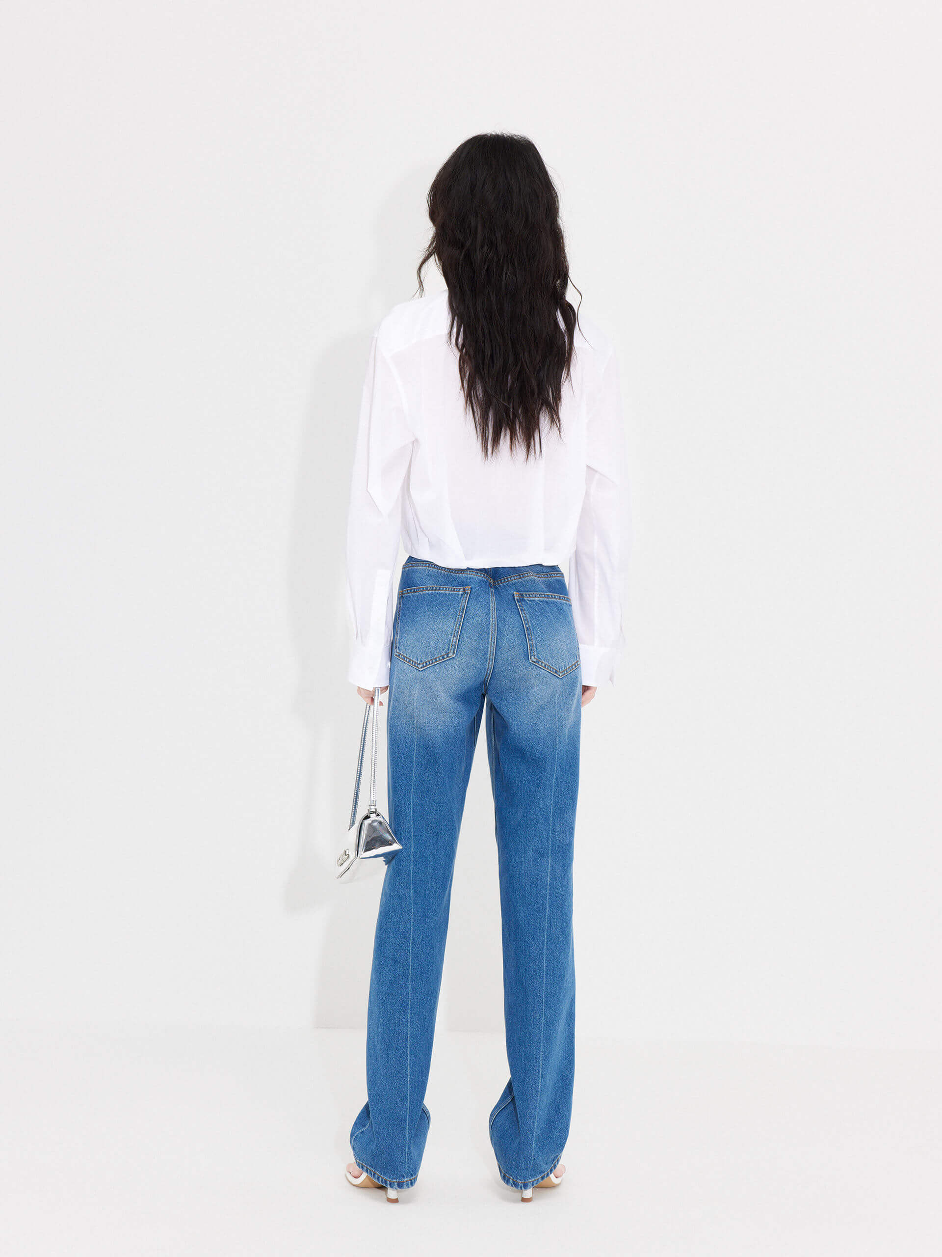 MO&Co. Women's Slanted Placket Cropped Shirt in White. Crafted with a stylish cropped silhouette and slanted placket design, this fashion-forward piece is bound to turn heads. Plus, it's complete with a front pocket and elastic hem for a unique look.