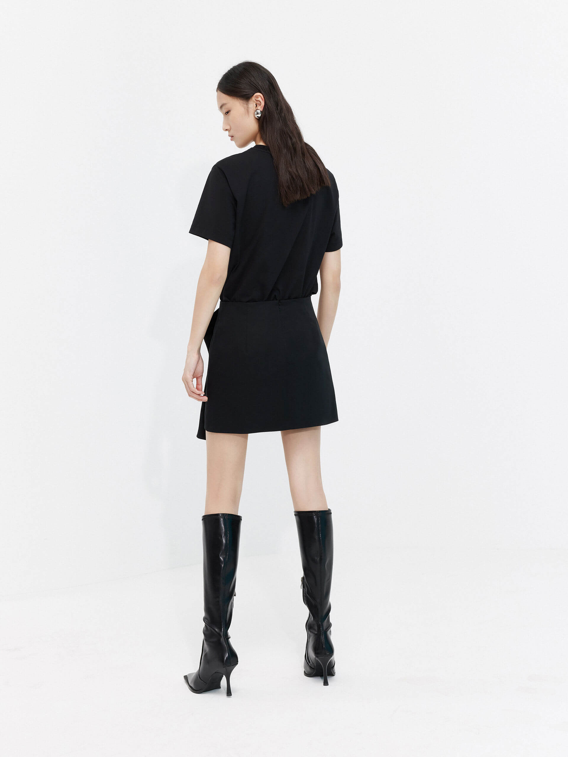 MO&Co. Women's Deconstructed Pleated Skirt in black. It features flattering pleats and draped front, inner shorts and a-line silhouette.