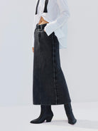 MO&Co. Noir Women's Straight Cut Denim Maxi Skirt Black Washed. Crafted from pure cotton, this skirt offers both comfort and style with its mid-length silhouette and side-washed fade effect.