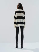 MO&Co. Noir Women's Distressed Detail Striped Oversized Pullover Crafted from a blend of mohair and wool, this sweater offers a fuzzy texture and distressed design for a modern twist. 