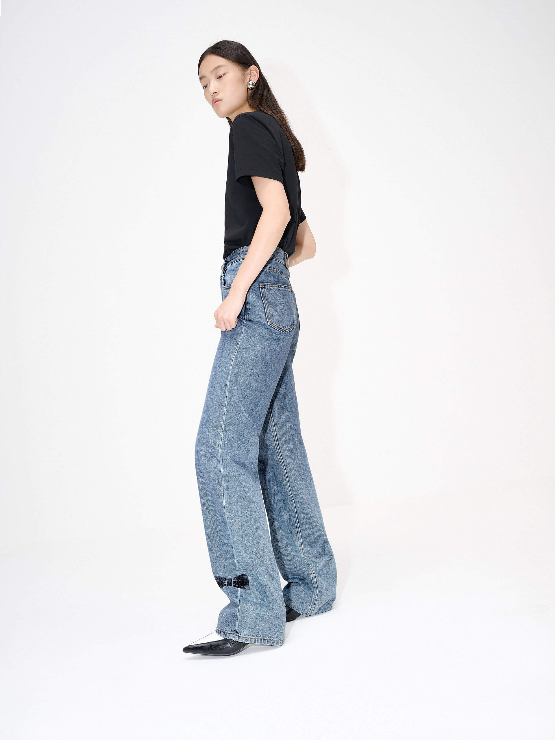 MO&Co. Women's Straight Bowknot Details Jeans in Blue. Featuring a high-waist design for a modern silhouette, these chic jeans are enhanced with bowknot-printed details at the back pocket and hem, adding a touch of femininity.