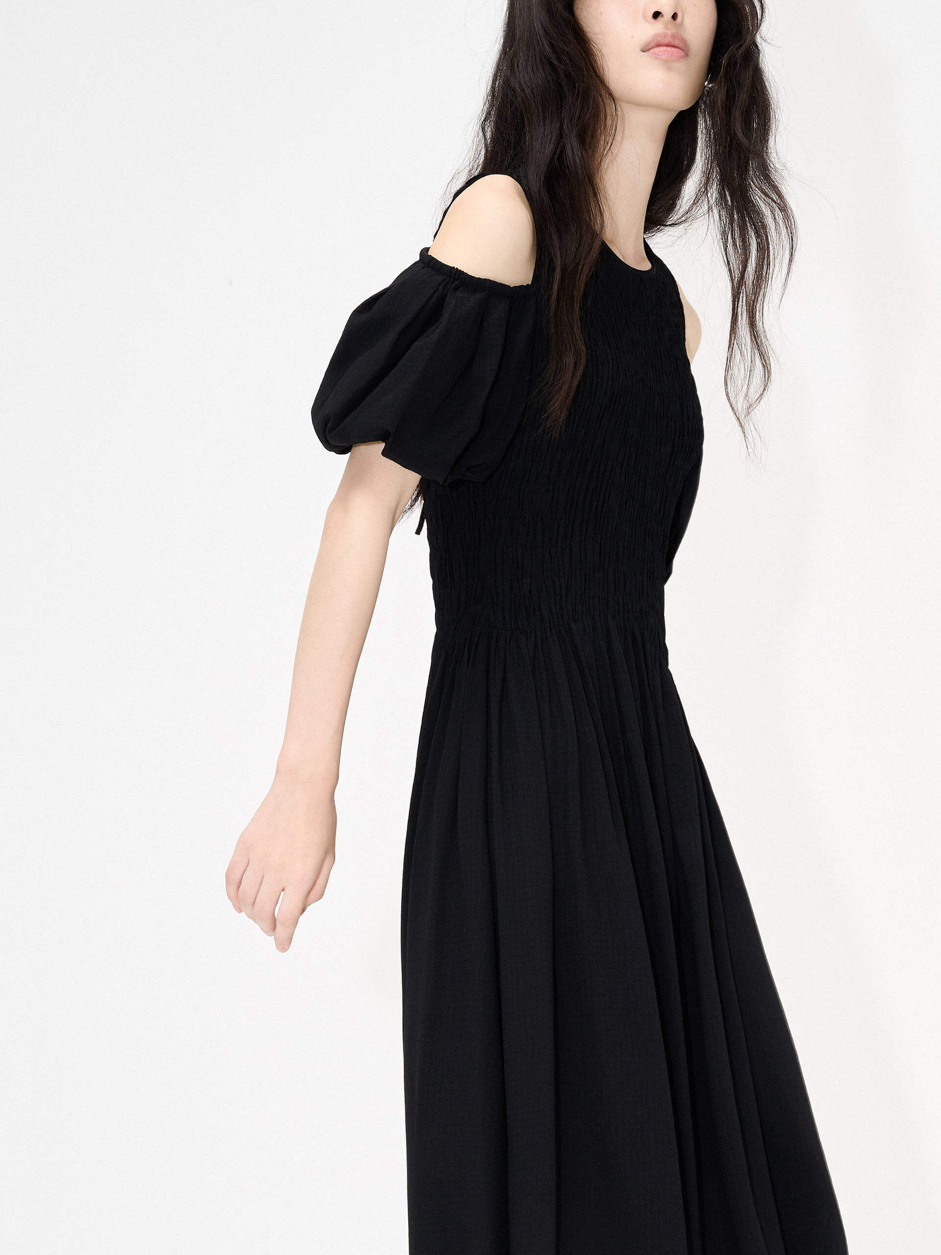 MO&Co. Women's Cut Shoulder Smocked Dress in Black. It features smocked detailing and shoulder cutouts for a flattering look with a unique, modern feel. Plus crafted from a blend of silk and polyester for an ultra-comfortable fit.