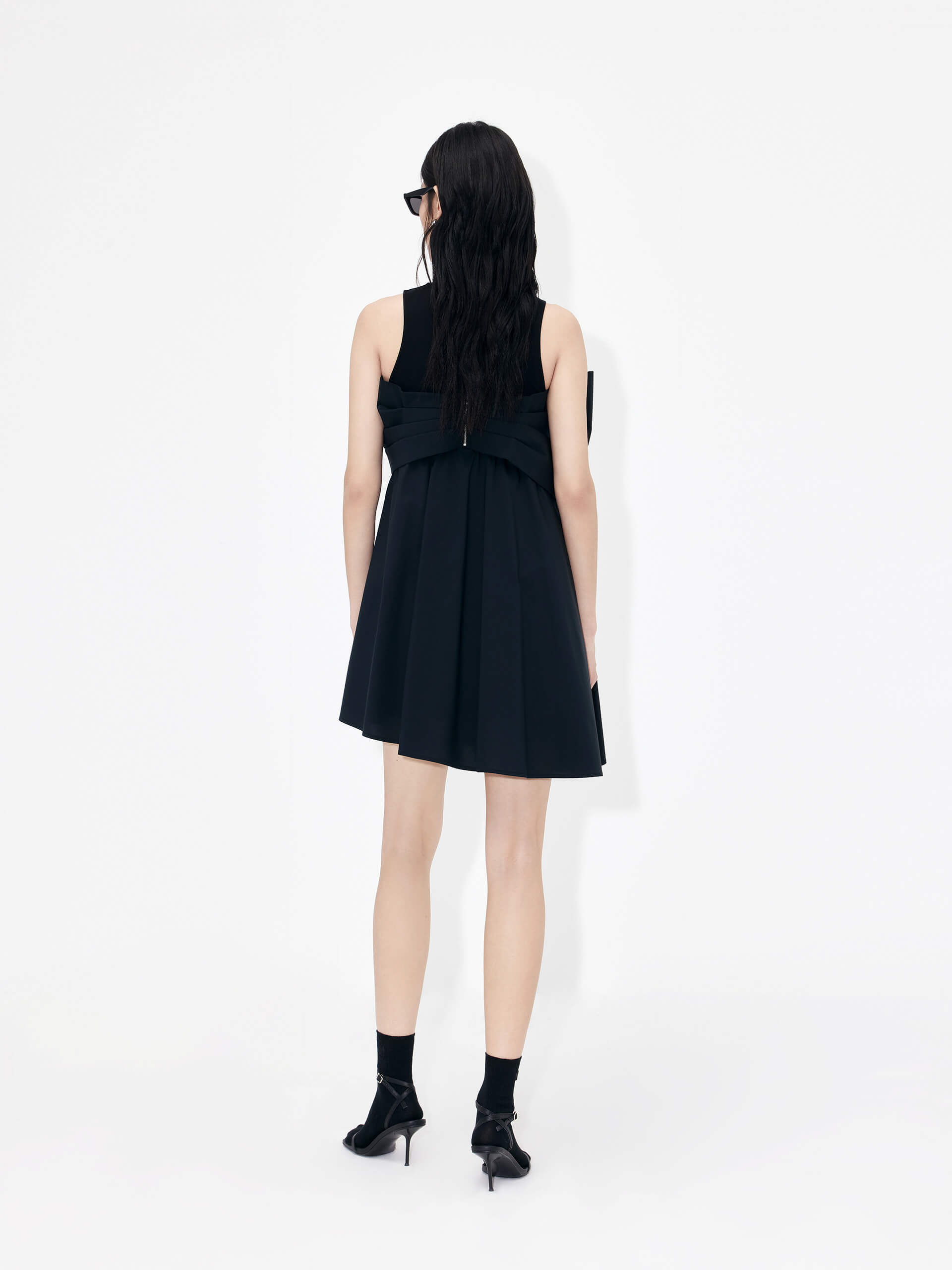 MO&Co. Bowknot Front Mini Dress in Black with sleeveless design. Crafted from a soft and breathable cotton blend, this feminine and sophisticated piece features an a-line silhouette with bowknot front details for an eye-catching look.