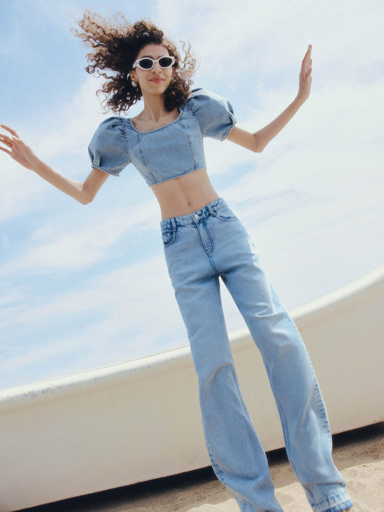 MO&Co. Women's Puff Sleeves Denim Cropped Top in Blue features puff sleeves and a smocked back with metallic tie details.