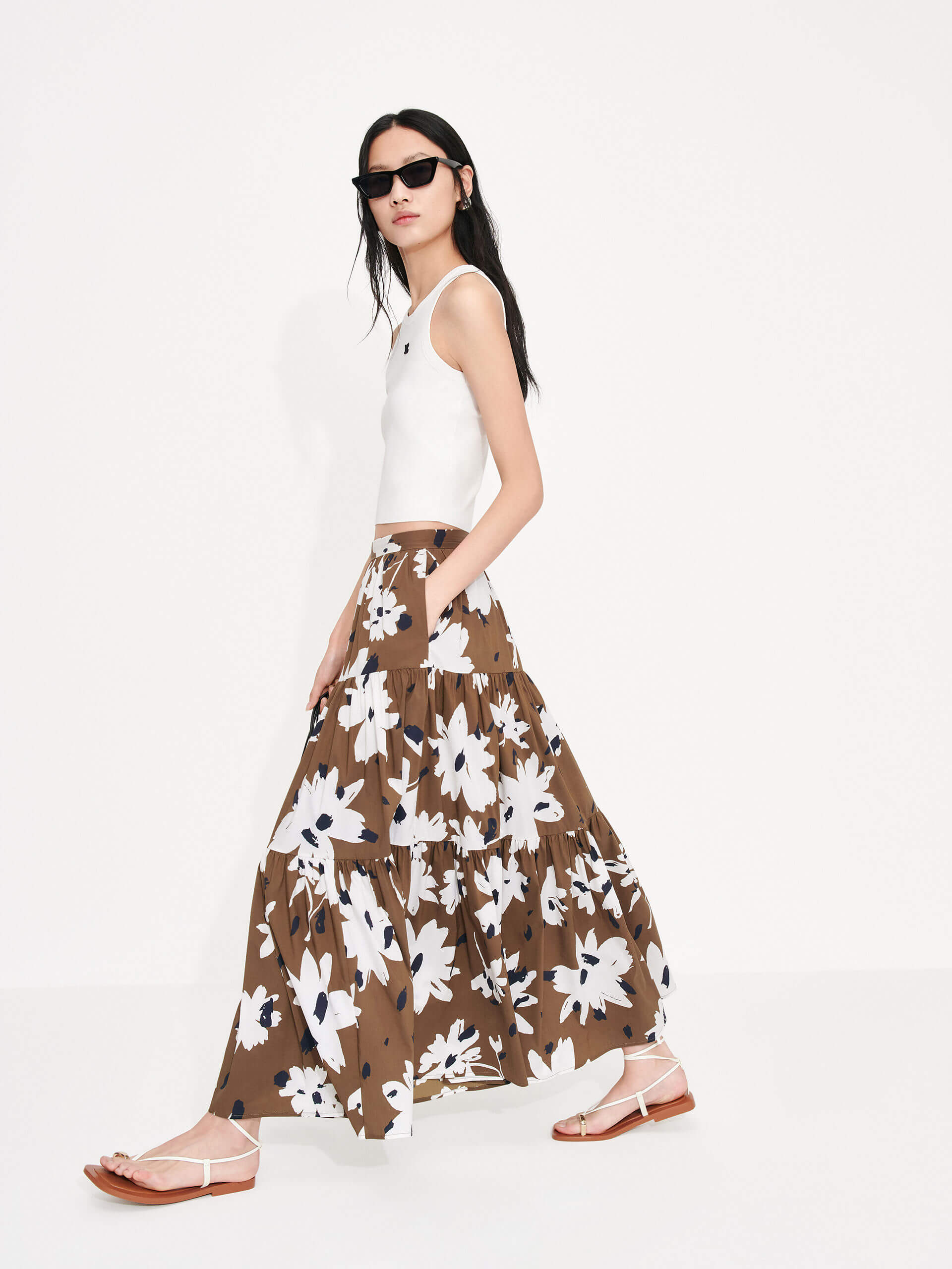 MO&Co. Women's Tiered Floral Print Maxi Skirt in Brown features a flowy fit, high waist and pleated design. Plus, the bold floral print and side zipper closure create a standout style.