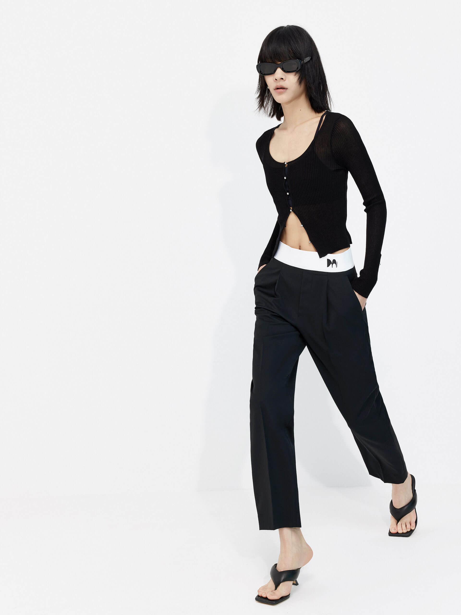 MO&Co. Women's Contrasting Details Suit Pants in Black. Crafted with a luxurious wool blend and featuring an eye-catching elastic waistband with an M pattern, these pants are designed for comfort and style. Double-side pockets and side zip closure complete the look.