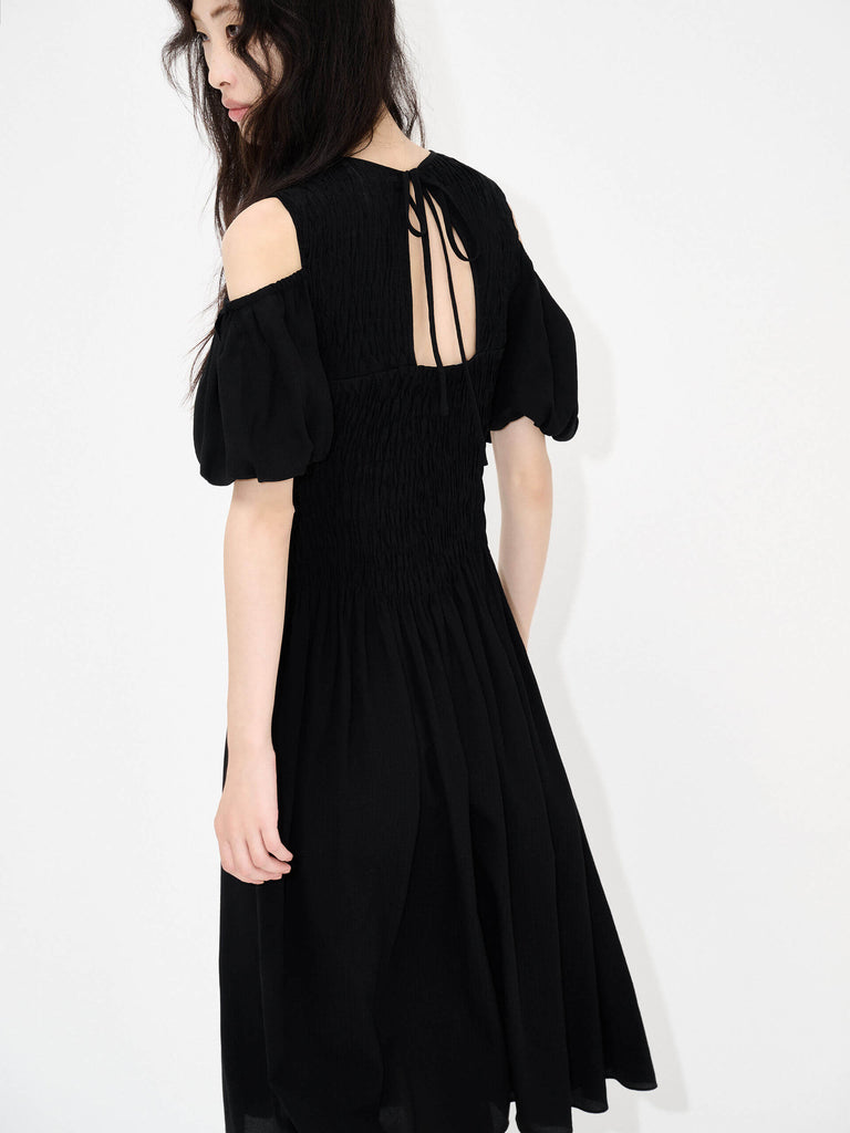 MO&Co. Women's Cut Shoulder Smocked Dress in Black. It features smocked detailing and shoulder cutouts for a flattering look with a unique, modern feel. Plus crafted from a blend of silk and polyester for an ultra-comfortable fit.