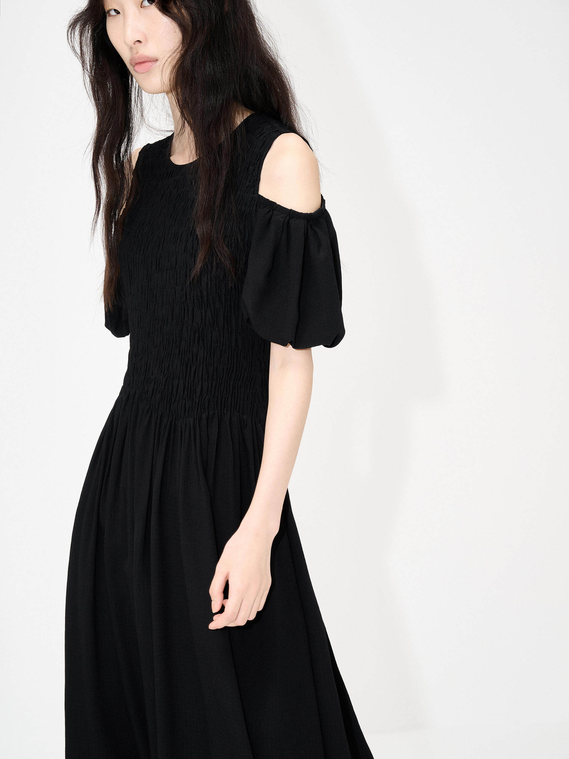 MO&Co. Women's Cut Shoulder Smocked Dress in Black. It features smocked detailing and shoulder cutouts for a flattering look with a unique, modern feel. Plus crafted from a blend of silk and polyester for an ultra-comfortable fit.