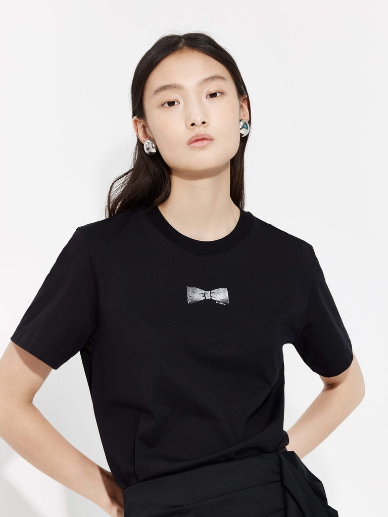 MO&Co. Women's Bowknot Pattern Cotton Blend Lightweight T-Shirt in Black features a crew neckline regular fit design and a stylish front bowknot pattern print.