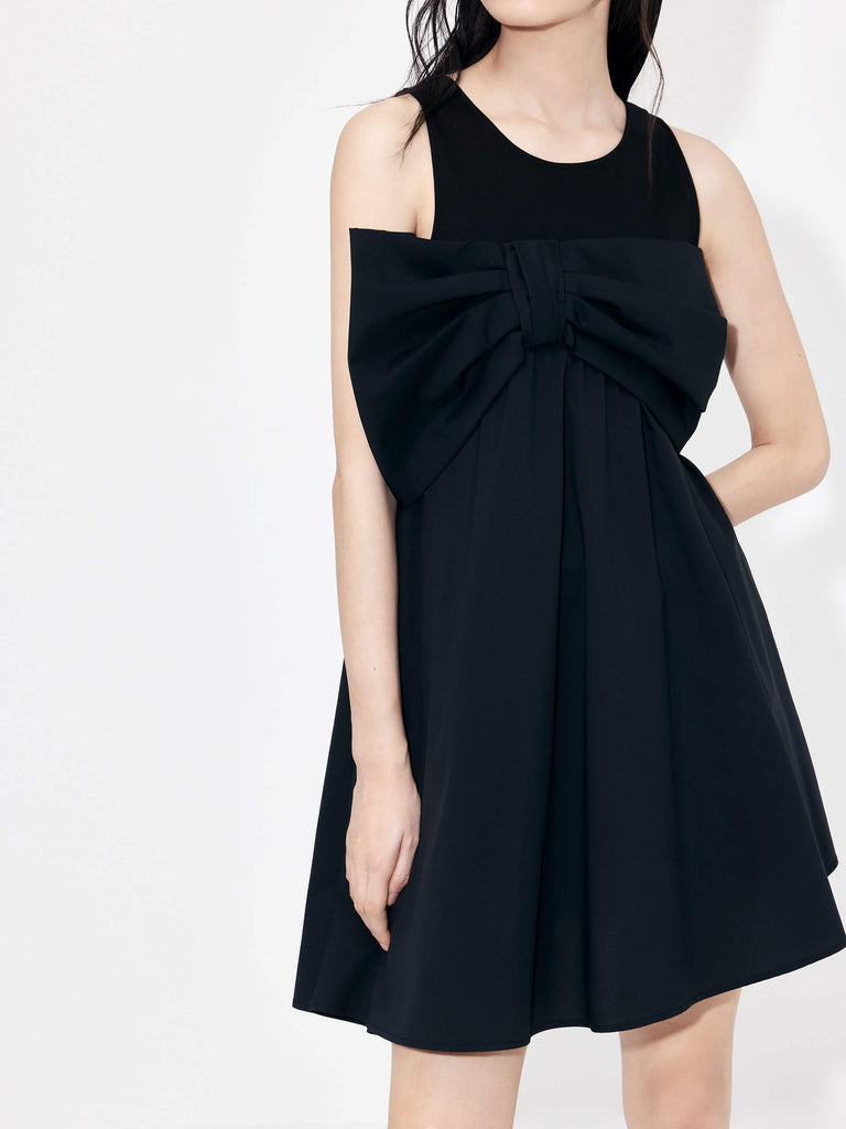 MO&Co. Bowknot Front Mini Dress in Black with sleeveless design. Crafted from a soft and breathable cotton blend, this feminine and sophisticated piece features an a-line silhouette with bowknot front details for an eye-catching look.