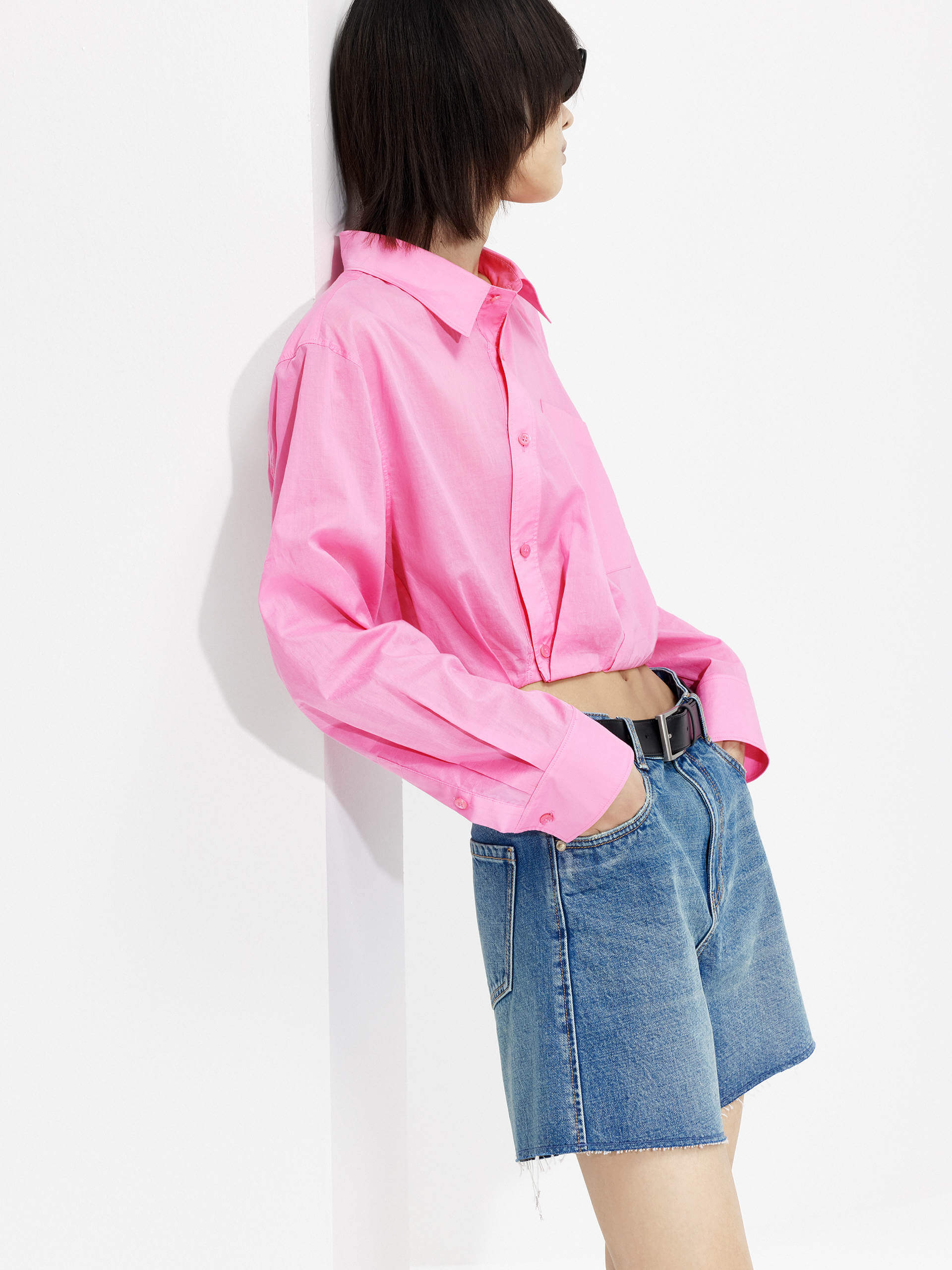 MO&Co. Women's Slanted Placket Cropped Shirt in Pink. Crafted with a stylish cropped silhouette and slanted placket design, this fashion-forward piece is bound to turn heads. Plus, it's complete with a front pocket and elastic hem for a unique look.