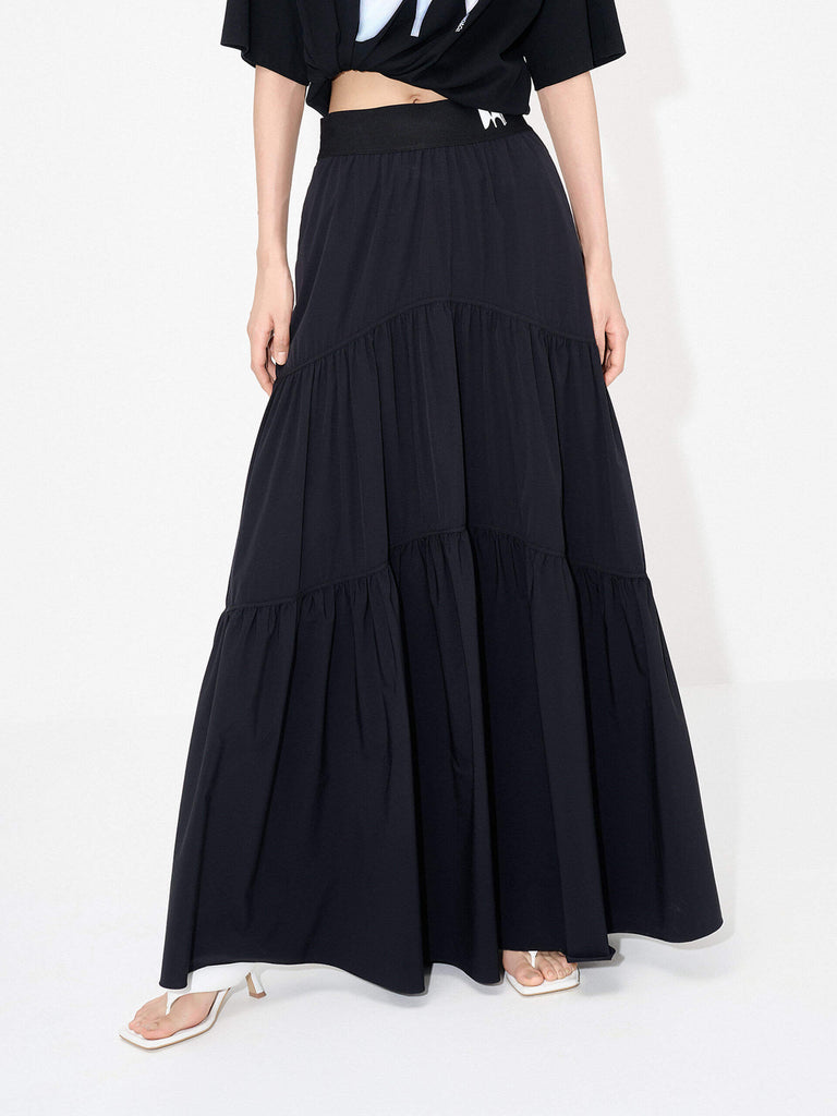 MO&Co. Women's Flowy Prairie Maxi Skirt in Black for Summer Day features double side pockets, cool-touch fabric, an elasticized waistband, and gathered seam details for a perfect fit.