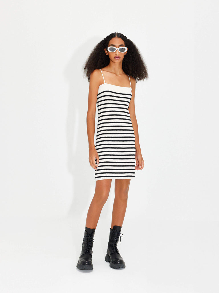 MO&Co. Women's Black Striped Straps All Day Mini Dress in White features a bodycon fit, metallic button front details, rib knitted and stretchy materials, and adjustable spaghetti straps with a striped pattern.