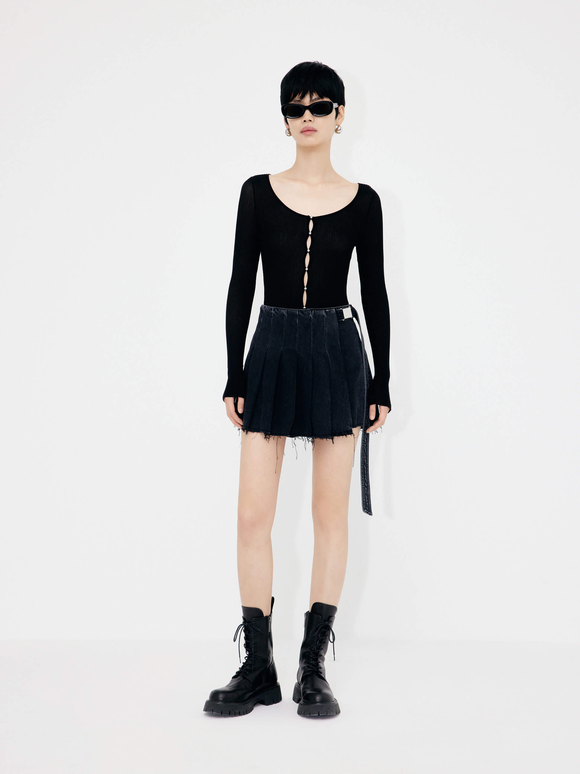 MO&Co.'s Women's Wrap Detail Pleated Black denim Shorts. Features include mini length, raw hem details and a wrap pleated patch with buckle belt.