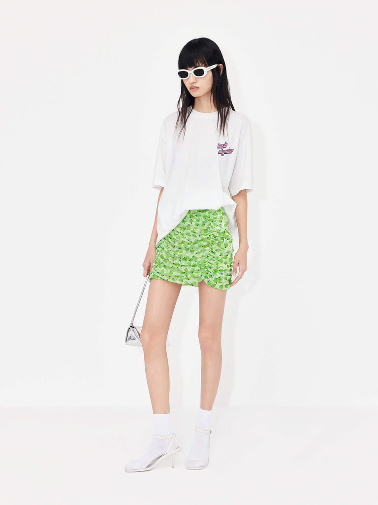 The MO&Co Women's Pleated Floral Print Mini Skirt in Green is a stylish wardrobe staple perfect for a polished look. Crafted from lightweight mesh with a pleated design, it features a classic flower print and draped detailing. A hidden side zipper and inner lining provide a comfortable, secure fit.
