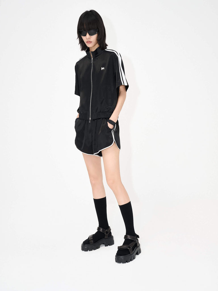 MO&Co. Women's Satin Acetate Blend Casual Track Jacket in Short Sleeves in Black. Features: Loose fit, contrasting trim design, elasticized hem, side pockets & zip closure, and an acetate blend fabric for softness & comfort.