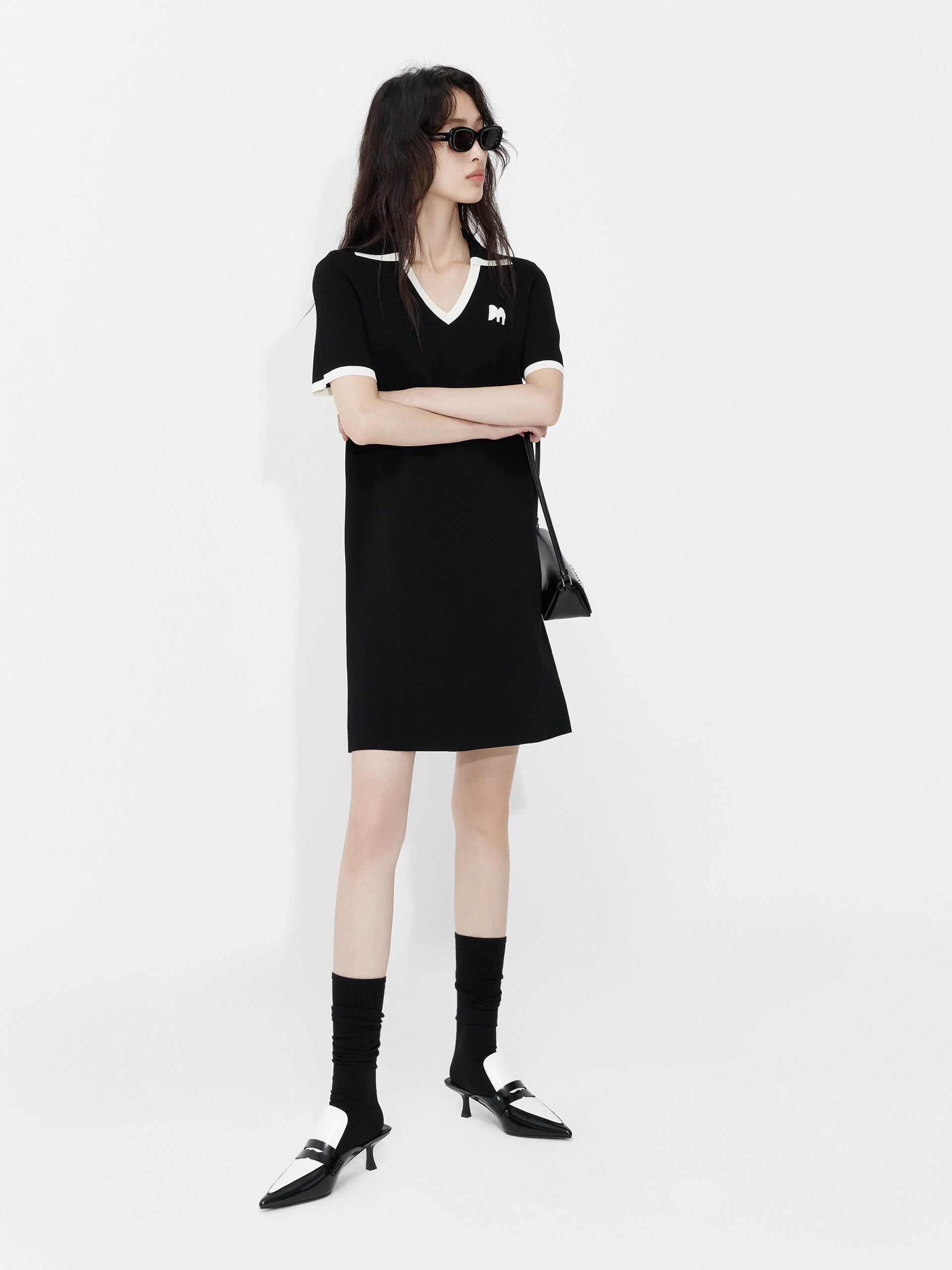 MO&Co. Women's Polo Collar Contrast Black Dress features include a V-neck with collar design, contrasting trim details, and an embroidered M logo patch front. 