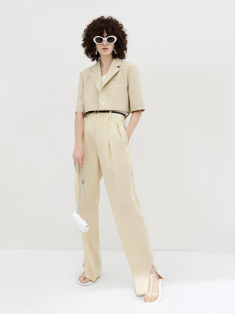 MO&Co. Women's Pleated Suit Pants with Belt in Camel features high-rise, slit detail at hems, straight leg fit.