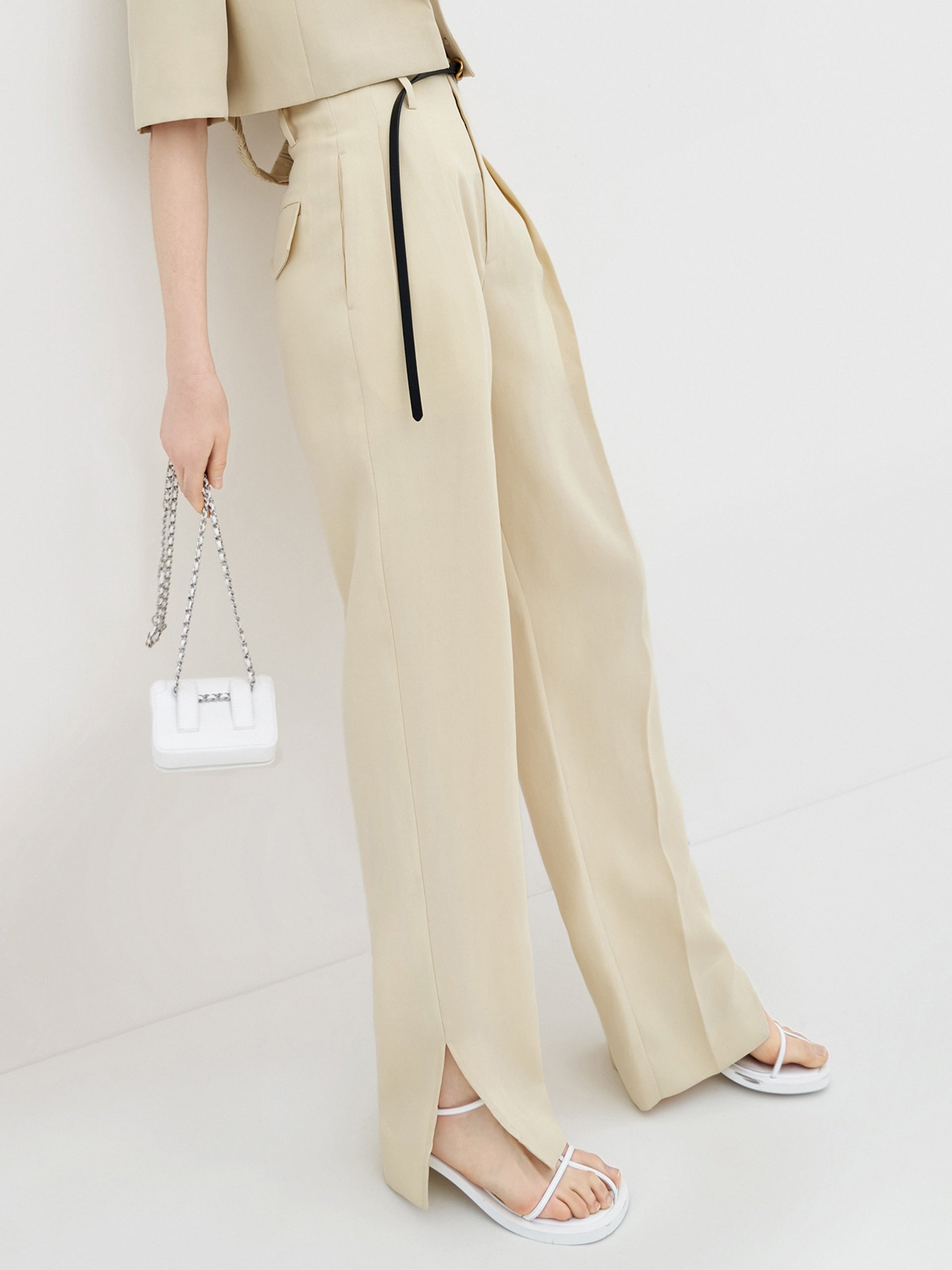 MO&Co. Women's Pleated Suit Pants with Belt in Camel features high-rise, slit detail at hems, straight leg fit.