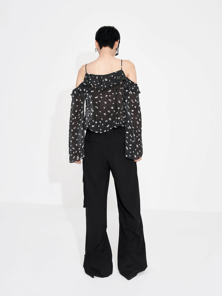 This MO&Co. Cut Shoulder Printed Top in Black is crafted from 100% recyclable fibers, making it a stylish and sustainable choice. Show off your fashion-forward style with off-shoulder trumpet sleeves, a floral and polka dot print, and pleated trim detailing on the front. Elevate your wardrobe with this statement piece!
