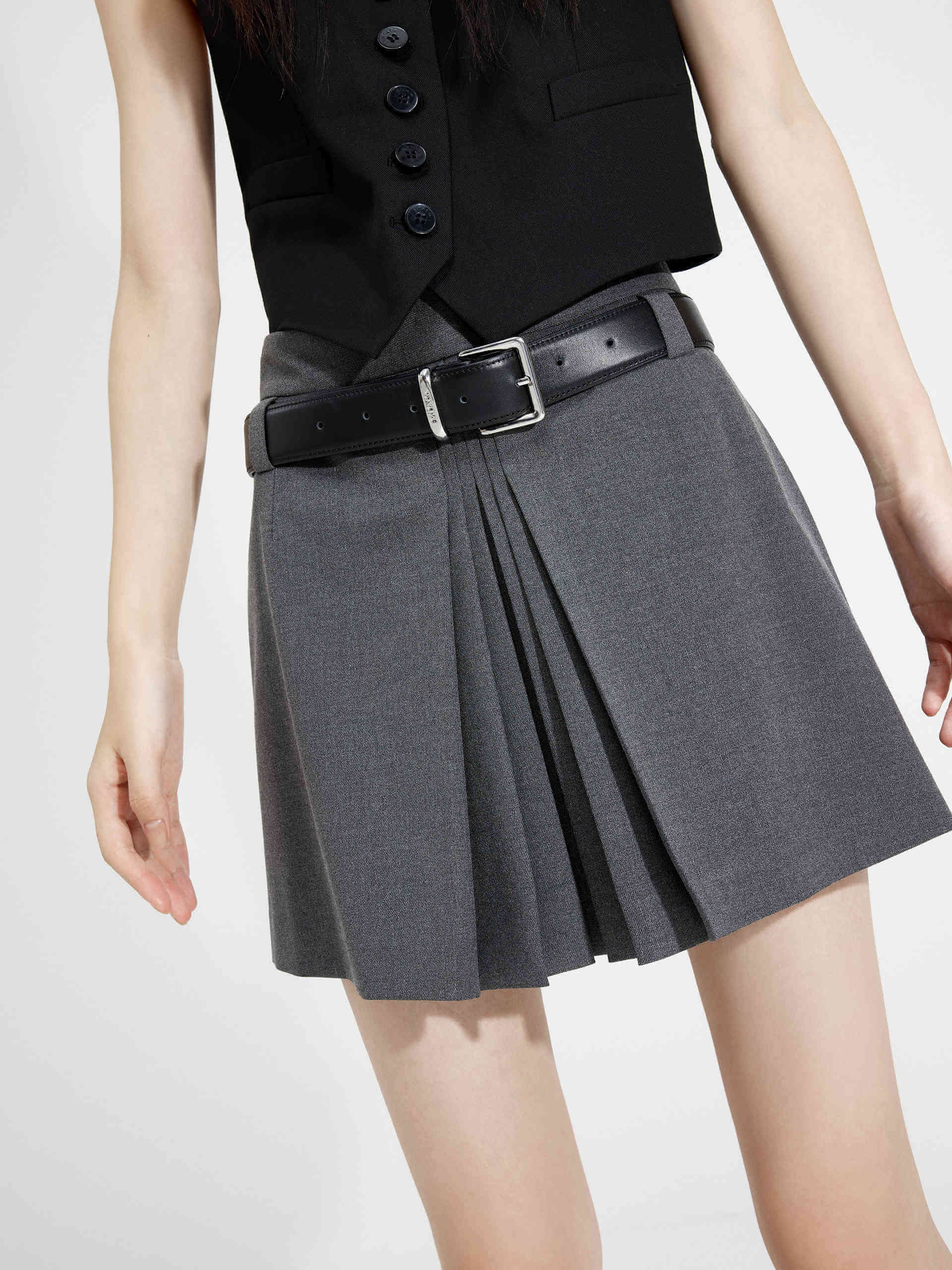 MO&Co. Women's Pleated Mini Skirt in Grey with Belt features mini length, pleated details at front, low-rise belt loops design & a hidden back zipper closure, it's sure to be a wardrobe staple! 